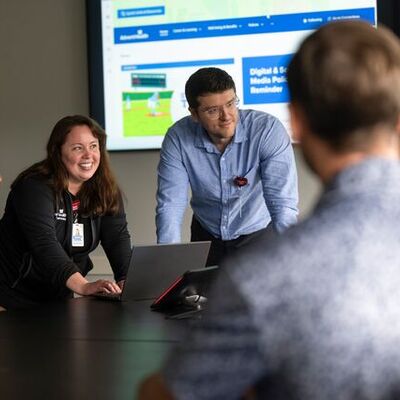 a group of people smiling and working together in a conference room.