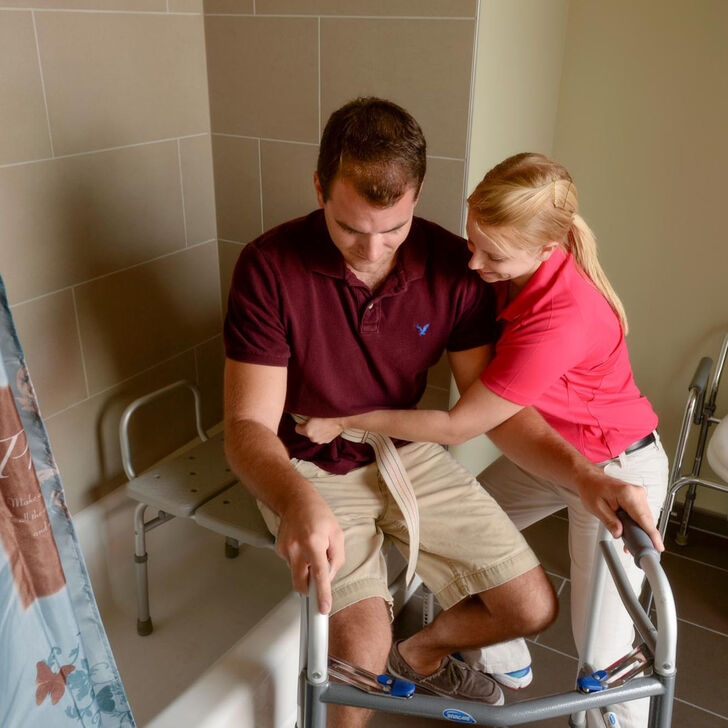 An occupational therapy student providing bathroom assistance.